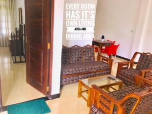 阿努拉德普勒Mindana Residence的配有椅子和桌子的房间和标志