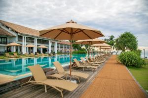 肯克拉The Fortress Resort & Spa的游泳池旁的一排椅子和遮阳伞