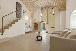 马蒂诺Relais Palazzo Zaccaria的带沙发和楼梯的客厅