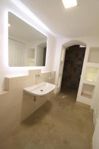 马蒂诺Relais Palazzo Zaccaria的白色的浴室设有水槽和镜子