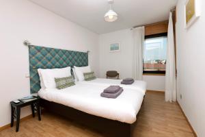 波尔图LV Premier Marques MQ2的一间卧室配有一张白色大床和绿色床头板