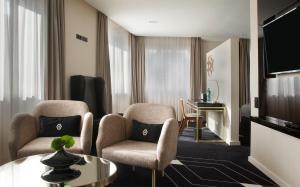 里斯本阿尔提斯亚芬尼达酒店的客厅配有两把椅子和一张桌子