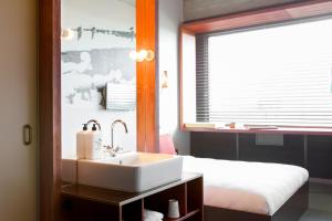 阿姆斯特丹沃克斯酒店的一间带水槽的浴室和一张带窗户的床