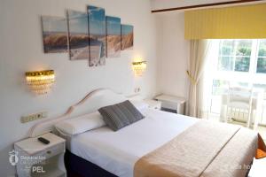 佩里洛Hotel Alda Santa Cristina的卧室配有白色的床和窗户。
