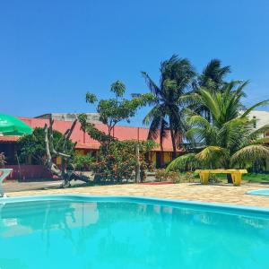 马拉塔伊济斯Pousada dos Gravatais的棕榈树度假村前的游泳池