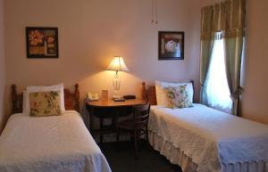 圣彼得堡昂色德旅馆的客房设有两张床和一张带台灯的桌子。