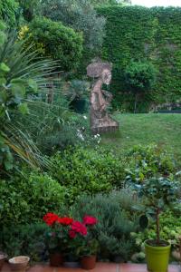 图卢兹CHAMBRE SPACIEUSE DANS MAISON ART DECO au CENTRE DE TOULOUSE的花园中妇女拿着雨伞的雕像