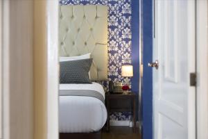基多TERRA PREMIUM Hostal Boutique的一间卧室配有蓝色和白色壁纸的床