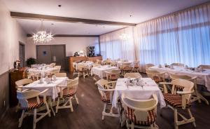 贝科莫拉卡拉维尔酒店的餐厅配有白色的桌椅和吊灯
