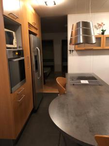 格仑达积图Sæból/Ocean Lair 2的厨房配有桌子和不锈钢冰箱。
