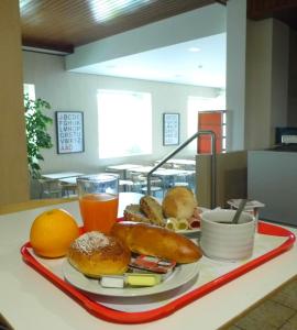 恩特龙卡门图加梅罗酒店的桌上的百吉饼和橙汁托盘