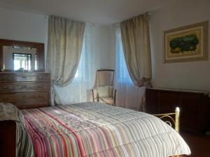 塞拉韦扎Antico Uliveto的一间卧室配有一张床、梳妆台和椅子