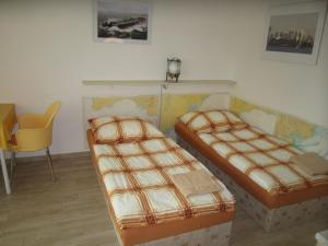 大梅济日奇Penzion Letná的一间卧室配有两张床和一张黄色椅子