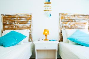 法马拉Casa Ada 2的两张带蓝色枕头的床和床头柜上的灯