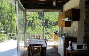 卡洛帕尼亚伊奥蒂斯圣安布罗西安德洛尼卡乡村民宿的带桌子的厨房和带阳台的厨房