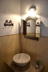门多萨玛格丽特公寓酒店 的浴室设有水槽和墙上的两面镜子