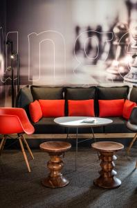 库尔布瓦宜必思巴黎拉德芳斯库尔布瓦酒店的一张带橙色枕头的沙发和桌椅