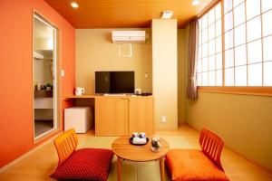 东京日暮里旅馆和的客厅配有桌椅和电视。
