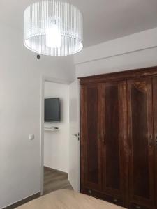 阿利坎特Alicante centre ,Plage et Quartier animé,Wifi Clim的一间卧室配有木制橱柜和吊灯。