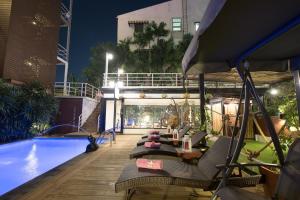 曼谷暹罗披曼酒店 的一个带椅子的庭院和夜间游泳池