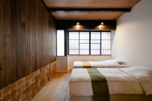 京都Machiya Hotel YANAGI的一间卧室设有两张床和窗户。
