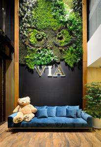 台北丰居旅店 - 北车馆的坐在植物前蓝色沙发上的泰迪熊