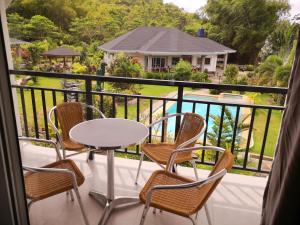 锡基霍尔花园度假别墅的阳台配有桌椅,享有房屋的景致。