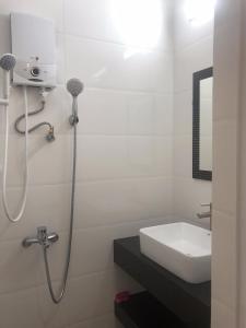 大叻Ruby Dalat Hostel的白色的浴室设有水槽和淋浴。