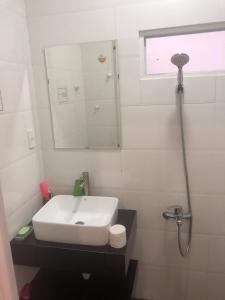 大叻Ruby Dalat Hostel的白色的浴室设有水槽和镜子