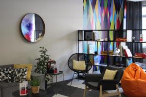 克罗勒Ibis Styles Crolles Grenoble A41的客厅配有沙发、椅子和镜子
