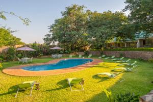 维多利亚瀑布Batonka Guest Lodge的一个带椅子的庭院和一个游泳池