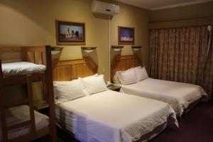 金伯利Kalahari Lodge Kimberley的酒店客房设有两张床和窗户。