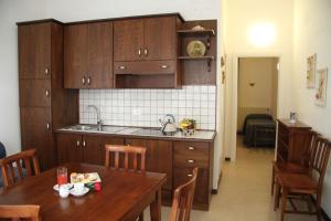 格罗塞托港卡夫普里斯科公寓的厨房配有木制橱柜和木桌,客人可在餐桌上用餐。