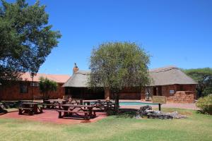 金伯利Kalahari Lodge Kimberley的一组野餐桌在建筑前