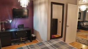 埃德蒙顿North London Apartment - Edmonton的一间卧室配有一张床、一张书桌和一面镜子