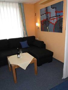 卡尔斯哈根Am Maiglöckchenberg 19的客厅配有黑色沙发和桌子