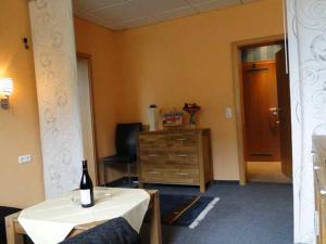 卡尔斯哈根Am Maiglöckchenberg 19的一间房间,配有一张桌子和一瓶葡萄酒