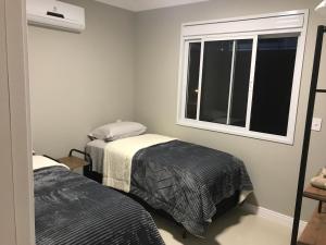弗洛里亚诺波利斯Ocean Life的一间卧室设有两张床和窗户。