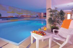 纽伦堡洛伊斯默库尔环形酒店的游泳池前的桌子上放着一碗水果