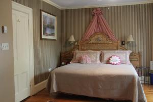 夏洛特顿船匠旅馆的卧室配有一张带粉红色枕头的大床