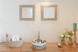 卢汉德库约Villa Trinidad Guesthouse的浴室设有水槽和墙上的两面镜子