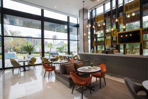 伊兹密尔ibis Styles Izmir Bornova的餐厅设有桌椅和窗户。