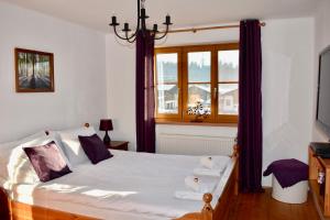 维尔芬翁Haus Thomas的一间卧室配有一张大床和紫色窗帘