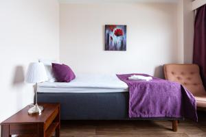 约恩苏Hotel Julie的一间卧室配有一张床铺,床上铺有紫色毯子