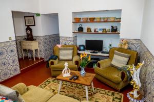 英雄港Quintal d'Angra的客厅配有2把椅子和书桌