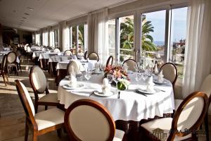 罗列特海岸阿尔巴塞勒克塔酒店的餐厅设有白色的桌椅和窗户。
