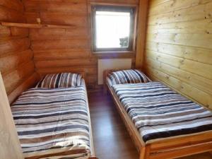 科尔别卢夫Domek Na Stoku的小木屋内的两张床,设有窗户