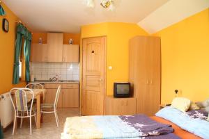 费尔特德Bo-Ni Vendégház的一间卧室配有床,厨房拥有黄色的墙壁