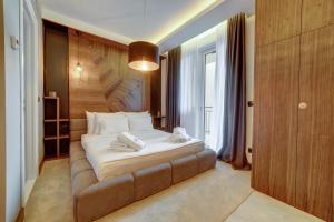 贝尔格莱德Black Pearl Luxury Suites的一间卧室配有一张大床和棕色沙发