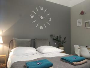弗罗茨瓦夫Apartament Easy Stay Center的卧室配有一张挂在墙上的带时钟的床